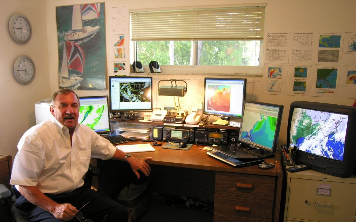Capt. Bob Cook monitoring weather and routing screens, sending a mid-passage update